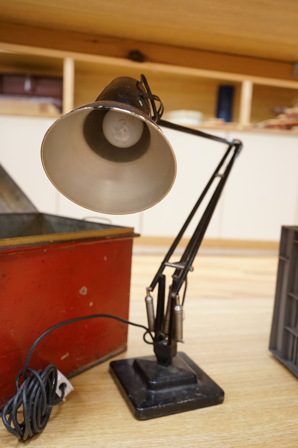 An Anglepoise lamp and metal door furniture and fittings in a tin trunk